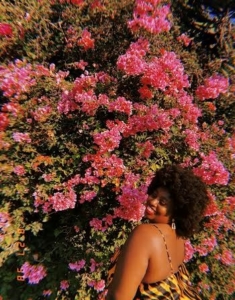 Photo of Ebony Oldham in front of a flower wall.