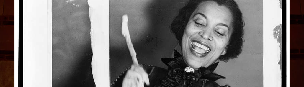 Zora Neale Hurston smiling and looking down.