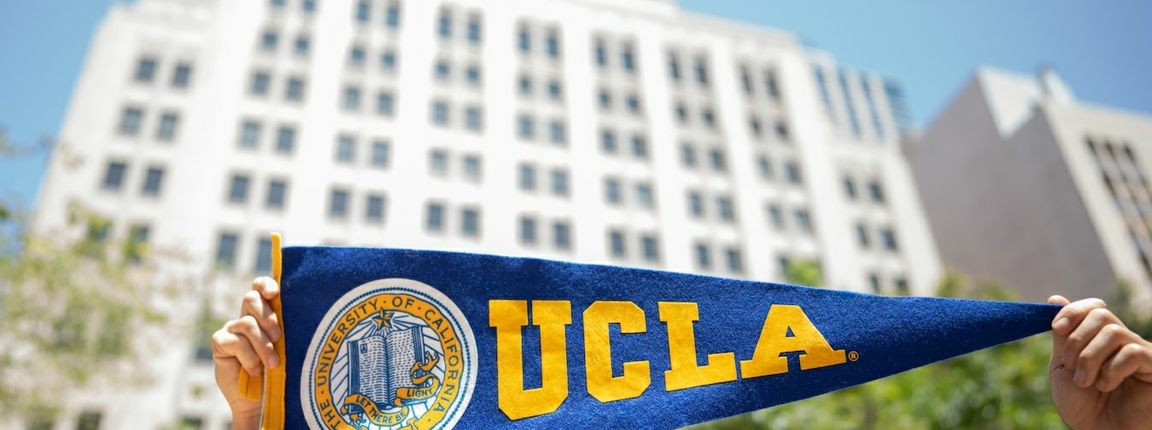UCLA flag in front of white building