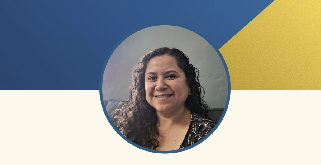 Headshot portrait of a smiling woman with long curly dark hair, shown inside a circular frame. She is wearing a dark patterned top and photographed indoors against a neutral background. The circular portrait sits on a graphic backdrop with a blue and gold diagonal design above and a light cream section below.