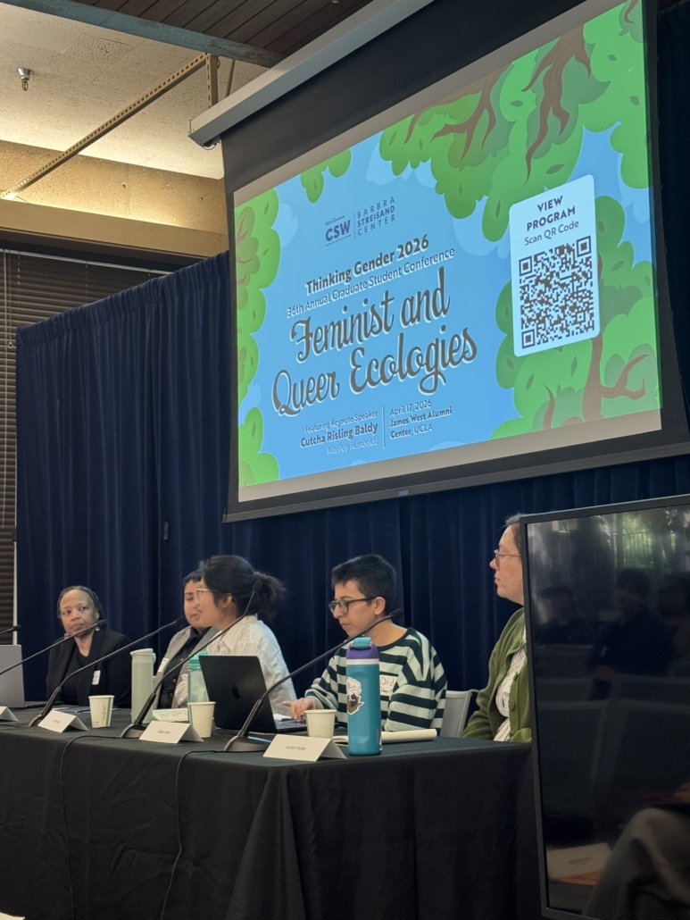 Panelists sit under a presentation screen.