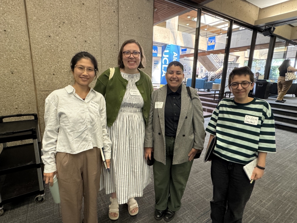 Four conference panelists dressed professionally.