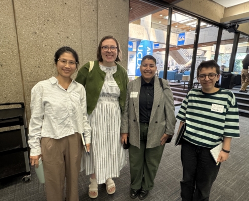 Four conference panelists dressed professionally.