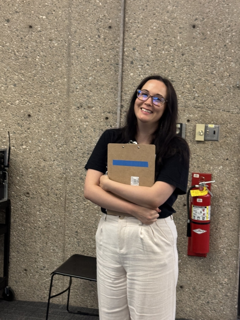Thinking Gender conference coordinator smiling and holding notebook.