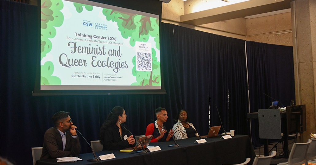 Four student panelists sit under a presentation screen.